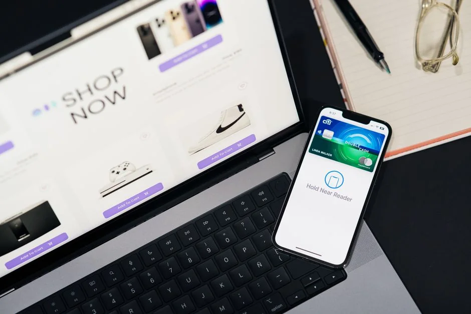 A miniature shopping cart with a parcel on a laptop symbolizes online shopping and e-commerce.