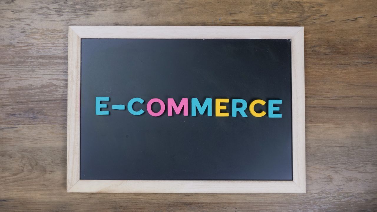 Services-02 Des lettres colorées formant e-commerce sur un tableau noir encadré de bois.